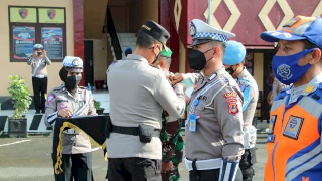 Kapolres Soppeng, AKBP Santiadjie Kartasasmita mengenakan pita kepada personil Lalu Lintas Polres Soppeng, Senin 3 Oktober 2022. (Ist)