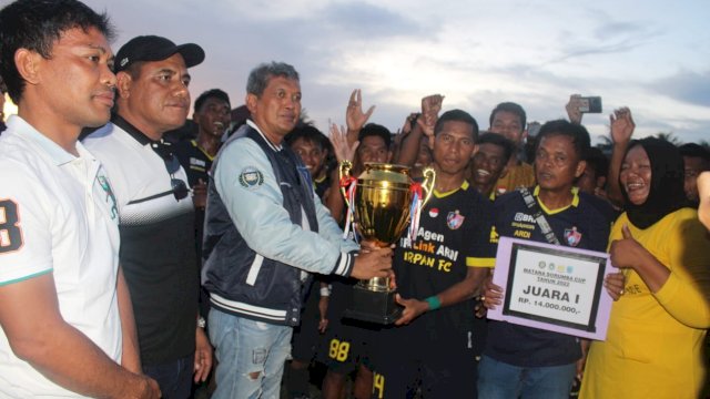 Pj. Bupati Buteng Muhammad Yusup saat menyerahkan piala juara 1 Matana Soromba Cup I kepada Irpan FC, Minggu (09/10/2022).