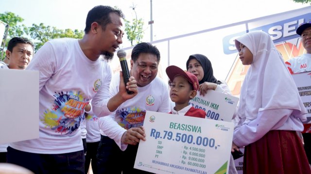 Gubernur Sulsel menyerahkan beasiawa secara simbolis kepada Siswa SD di kegiatan jalan sehat 353 Tahun Sulsel, Minggu (16/10/2022). (Istimewa)