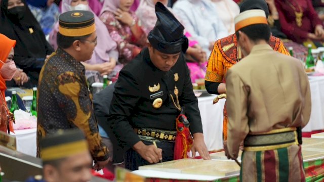 Gubernur Sulsel Andi Sudirman Sulaiman, menandatangani prasasti peresmian 10 fasilitas air siap minum di 8 Kabupaten dan Kota, saat Rapat Paripurna DPRD Sulsel memperingati HUT ke 353, Rabu (19/10/2022). (Istimewa)