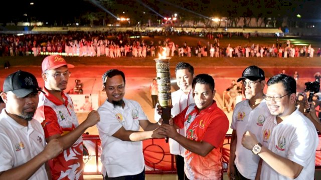 Gubernur Sulsel Andi Sudirman Sulaiman, memegang obor pembukaan Porprov Sulsel di Lapangan Andi Bintang Kabupaten Sinjai, Sabtu (22/10/2022). (Istimewa)