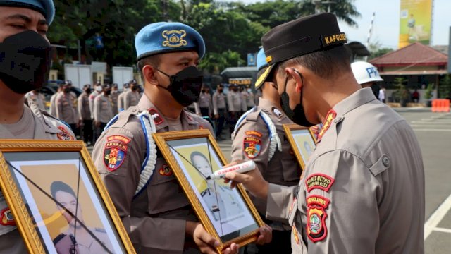 Kapolres Metro Tangerang Kota Kombes Pol Zain Dwi Nugroho, memberikan tanda silang ke Foto Empat Anggota saat Prosesi PTDH. (Istimewa)