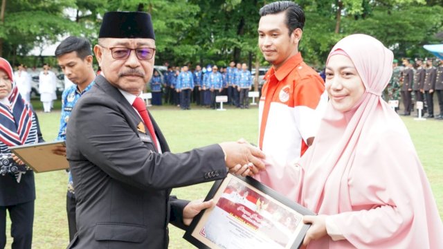 Wakil Bupati Gowa Abd Rauf Malaganni, saat menyerahkan penghargaan kepada pemuda prestasi di tengah-tengah pelaksanaan Hari Sumpah Pemuda di Lapangan Upacara Kantor Bupati Gowa, Jumat (28/10/2022). (Dok. Humas Gowa)