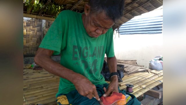 Kakek La Dima, saat menjahit sepatu milik warga. (Istimewa)