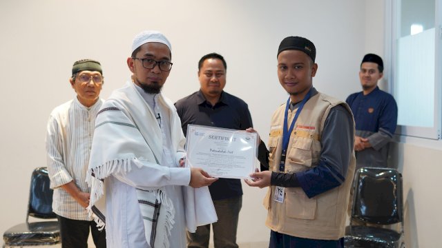 Salah satu imam menerima sertifikat kelulusan dari Pimpinan Quantum Akhyar Institut, Ustad Adi Hidayat (kiri) disaksikan Kabag Kesra Sekretariat Kabupaten Gowa Taufik Akib (tengah) pada Penutupan Program Peningkatan Kompetensi Imam Gelombang II Pemerintah Kabupaten Gowa Tahun 2022 Kerjasama At-Taisir Learning Centre Quantum Akhyar Institute Bekasi, di Jawa Barat (19/11). (Dok. Istimewa) 