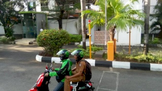 Kepala Sub Bagian Hubungan Masyarakat Sekretariat DPRD Kota Makassar, Akbar Rasyid naik ojek online menuju kantornya, Selasa (1/11/2022). (Foto: Istimewa)
