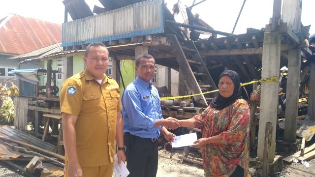 Kepala Sekolah SMP Negeri Satap Kollo, Nurwahid,S.Pd didampingi salah satu guru ketika menyerahkan bantuan donasi uang kepada salah satu korban kebakaran di Desa Kapota Utara, Selasa (08/11/2022). (Istimewa)