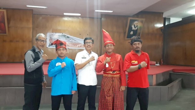 Kepala Bidang Kebudayaan, Disparbud Gowa Iqbal (tengah) berfoto dengan pJuara 1 dan 2 lomba Angngaru' antar pelajar SMP di Kabupaten Gowa bersama para juri usai perlombaan di Balla Lompoa, kemarin. (Dok. Disparbud Gowa)