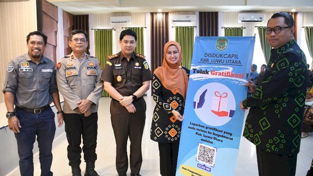Bupati Luwu Utara Indah Putri Indriani memyerahkan banner barcod scanner kepada Kepala Dinas Kependudukkan dan catatan sipil Luwu Utara. Barcode ini layanan untuk melaporkan jika terjadi adanya pungli atau tindak pidana korupsi.