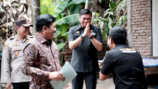 Bupati Gowa Adnan Purichta Ichsan (tengah) saat mendampingi Menteri ATR/BPN Hadi Tjahjanto (kiri) saat memberikan sertifikat tanah program PTSL kepada salah satu warga di Kampung Parang, Desa Maccini Baji, Kecamatan Bajeng, Jumat (25/11). (Dok. Humas Gowa)