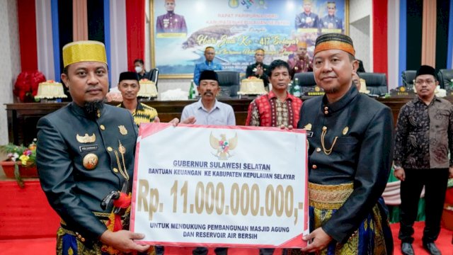 Gubernur Sulsel Andi Sudirman Sulaiman, menyerahkan bantuan keuangan secara simbolis kepada Bupati Kepulauan Selayar Basli Ali. (Istimewa)