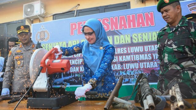 Bupati Luwu Utara Indah Putri Indriani saat memotong salah satu senjata api rakitan di halaman Mako Polres Luwu Utara. Selasa (29/11/2022)