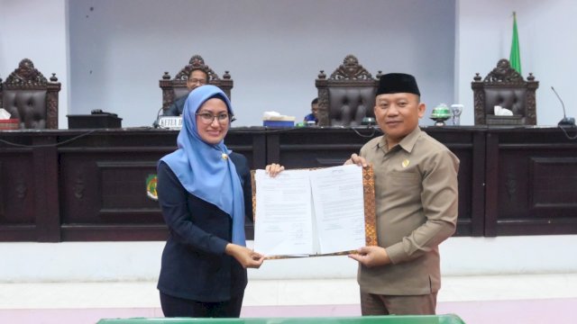 Wakil Ketua DPRD Luwu Utara Awaluddin, bersama Bupati Luwu Utara Indah Putri Indriani, usai mengeshkan Ranperda APBD TA 2023 menjada perda di Ruang Rapat Paripurna DPRD Luwu Utara, Selasa (29/11/2022). (Istimewa)