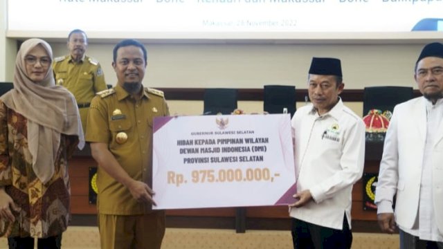 Gubernur Sulsel Andi Sudirman Sulaiman, didampingi Ketua Komisi D DPRD Sulsel Andi Rachmatika Dewi, menyerahkan dana hibah kepada Sekretaris Umum DMI Sulsel Hasid Palogai, Senin (28/11/2022). (Istimewa)