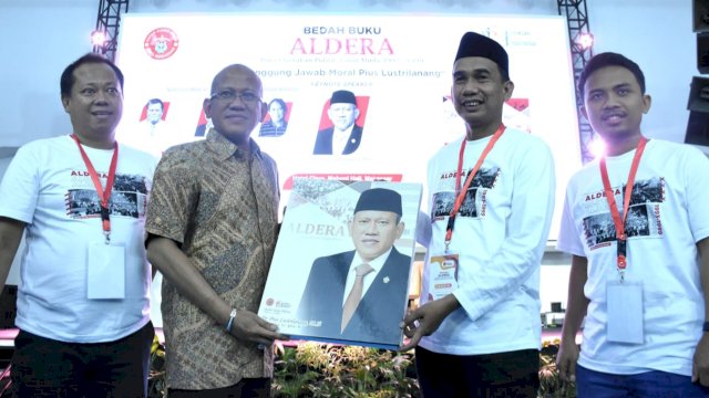 Ketua DPRD Makassar, Rudianto Lallo menyerahkan penghargaan kepada Pius Lustrilanang dalam acara bedah buku Aldera di Hotel Claro, Makassar, Jumat (11/11/2022). (Foto: Istimewa) 