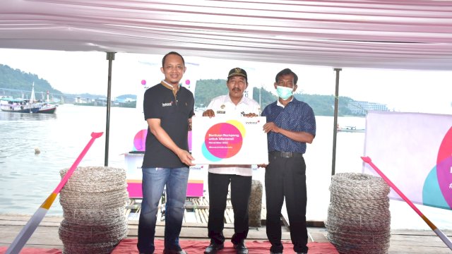 Kepala Desa Fatufia, Muhammad (tengah) sebagai perwakilan nelayan setempat saat menerima secara simbolik bantuan Rumpon dari Indosat Ooredoo Hutchison (IOH). Penyerahan bantuan ini sebagai upaya mendorong kesejahteraan komunitas nelayan di desa tersebut. (Dok. IOH Sumapa).