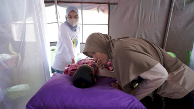 Seorang Ibu berusaha menenangkan anaknya yang sedang disunat saat kegiatan Bhakti Sosial Sunatan Massal yang diselenggarakan oleh PT. Vale, Minggu (11/12/2022). (Istimewa)