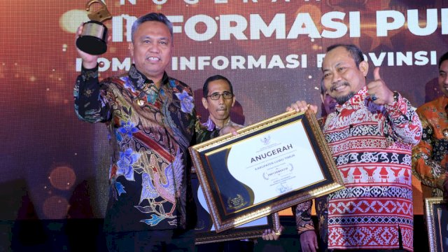 Bupati Luwu Timur, Budiman saat menerima penghargaan predikat Kabupaten Informatif 2022 dari Komisi Informasi Provinsi Sulsel.