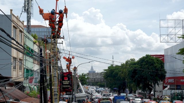 Petugas dari PLN UID Sulselrabar saat melakukan perbaikan instalasi Listrik di slaah satu ruas jalan di Kota Makassar beberapa waktu lalu. (Istimewa)