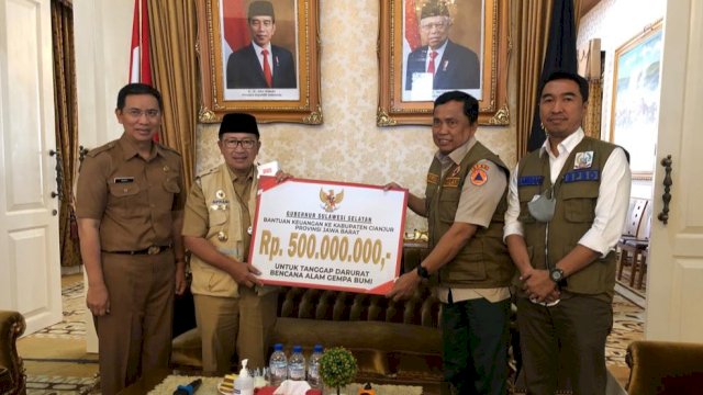 Kepala Pelaksana BPBD Sulsel Muhammad Firda, menyerahkan bantuan secara simbolis kepada Bupati Cianjur Herman Suherman, Senin (05/12/2022). (Istimewa)