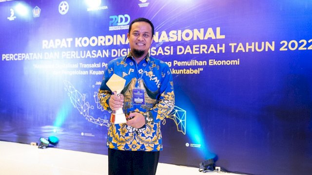 Gubernur Sulsel Andi Sudirman Sulaiman, memegang tropi penghargaan TP2DD. (Istimewa)