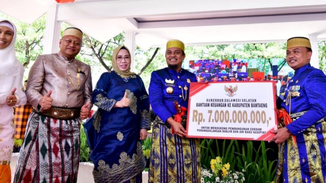 Gubernur Sulsel Andi Sudirman Sulaiman, menyerahkan bantuan keuangan kepada Bupati Bantaeng Ilhamsyah Azikin. (Istimewa)