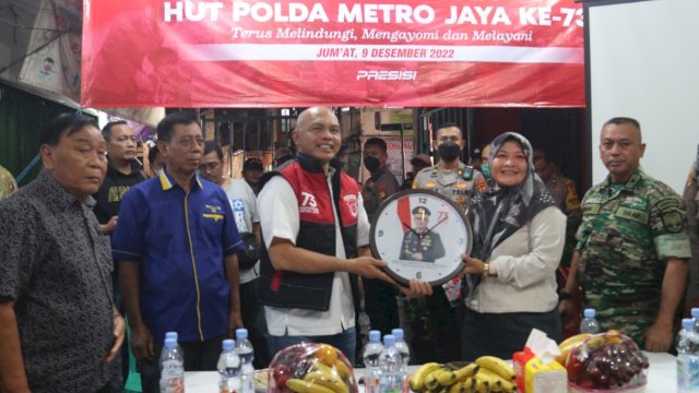 Wakapolda Brigjen Pol Hendro Pandowo, memberikan Souvenir HUT Polda Metro Jaya ke-73 kepada salah satu warga, Jumat (09/12/2022). (Istimewa)