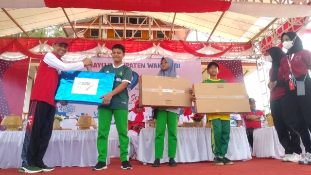 Bupati Wakatobi, Haliana, saat menyerahkan hadiah kepada salah satu peserta Jalan Santai HUT ke-19 Kabupaten Wakatobi, Sabtu (17/12/2022). (Istimewa)