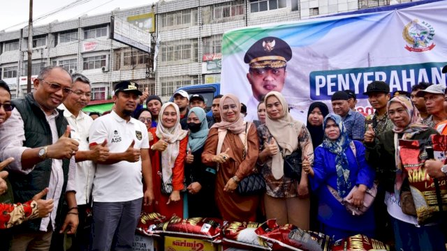 Gibernur Sulsel Andi Sudirman Sulaiman, saat menyalurkan bantuan untuk Pemilik Lapak Korban Kebakaran di Pasar Sentral Makassar. (Istimewa)
