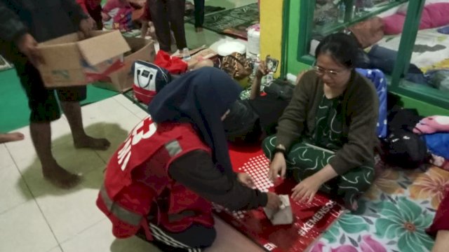 Petugas Medis dari PMI Kota Makassar melakukan pemeriksaan kesehatan kepada warga korban Banjir, Jumat (30/12/2022). (Istimewa)