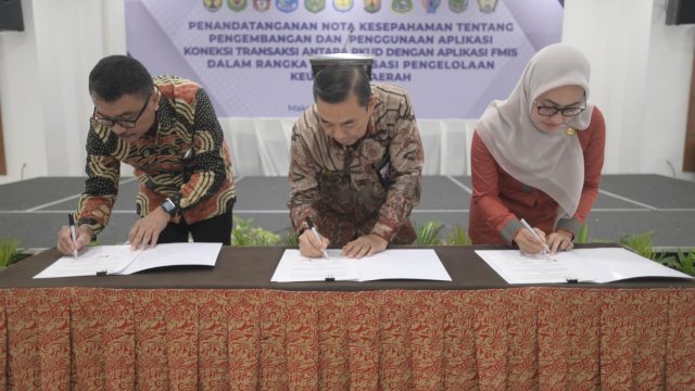 Bupati Luwu Utara Indah Putri Indriani (kanan) saat menandatangani nota kesepahaman tentang pengembangan dan penggunaan aplikasi koneksi transaksi antara Rekening Kas Umum Daerah (RKUD) dengan aplikasi Financial Management Information System (FMIS). Kamis (08/12/2022) di Hotel Claro, Makassar. FOTO/PROTOKOL LUWU UTARA
