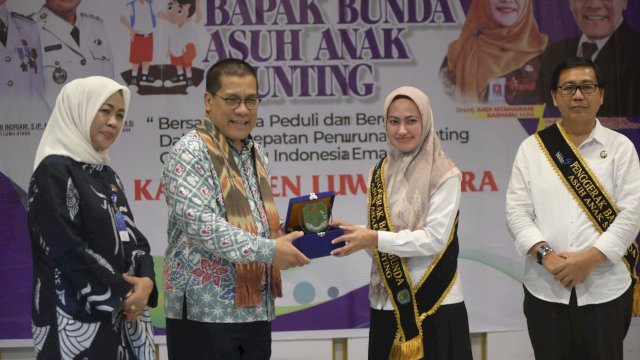 Bupati Luwu Utara Indah Putri Indriani menyerahkan cendra mata kepada Deputi Litbang BKKBN RI Prof Drh Muh.Rizal M Damanik. Jumat (09/12/2022) FOTO/PROTOKOL LUWU UTARA 