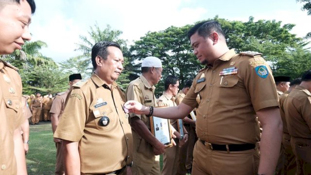 Bupati Gowa Adnan Purichta Ichsan saat menyerahkan penghargaan kepada salah satu kepala desa yang meraih Desa Mandiri, di Lapangan Upacara, Kantor Bupati Gowa, Senin (02/01). (Dok. Humas Gowa)