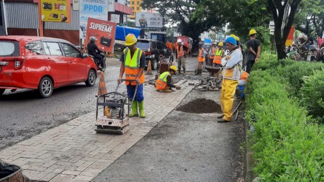 Petugas dari Dinas PUTR Sulsel saat melakukan penanganan di salah satu ruas jalan yang rusak parah di Kota Makassar. (Istimewa)