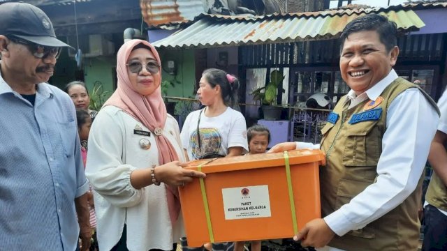Kepala BPBD Sulsel Amson Padolo, menyerahkan bantuan secara simbolis kepada korban kebakaran di Jalan Nuri Kota Makassar yang diterima oleh Lurah Mariso Hasmi Hasan, Rabu (18/01/2023). (Istimewa)