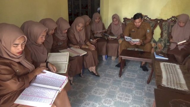 Kepala Desa Biringkassi, Kabupaten Takalar, dan 14 stafnya saat membaca Al-Qur'an setiap paginya sebelum memulai aktivitas pelayanan di kantor Desa, Rabu (18/01/2023). (Foto: Wawan Setiawan / Warga Kabupaten Takalar)