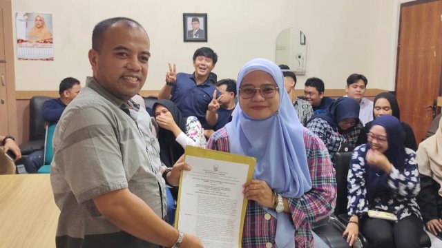 Sekretaris Dinas Kominfo-SP Sulsel Erwin Werianto, saat menyerahkan SK kepada salah satu Pegawai Non-ASN, di Ruang Kerjanya, Jumat (20/01/2023). (Istimewa)