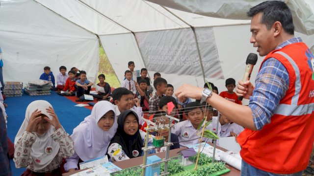 Petugas PLN saat memberikan pemahaman tentang Pembangkit Listrik kepada anak-anak korban gempa Cianjur. (Istimewa)