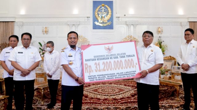 Gubernur Sulsel Andi Sudirman Sulaiman, menyerahkan bantuan keuangan secara simbolis ke Bupati Tana Toraja Theofilus Allorerung, Rabu (01/02/2023). (Istimewa)