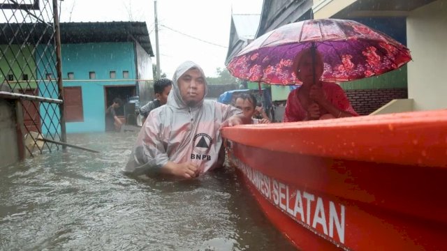Petugas BPBD Sulsel saat mengevakuasi korban banjir di Kota Makassar, Senin (16/02/2023). (Istimewa)