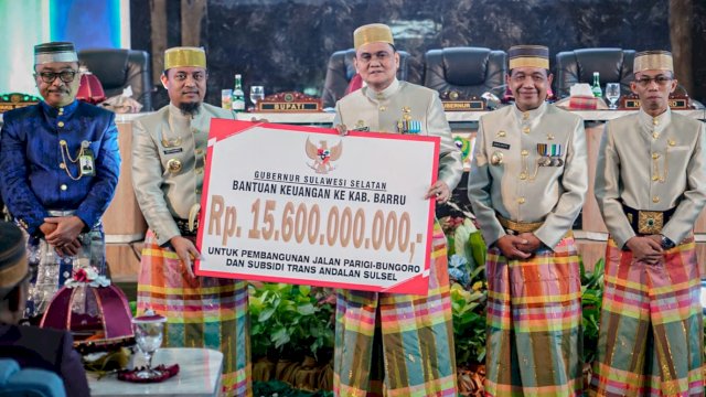 Gubernur Sulsel Andi Sudirman Sulaiman, menyerahkan bantuan keuangan secara simbolis kepada Bupati Barru Suardi Saleh, Minggu (26/02/2023). (Istimewa)