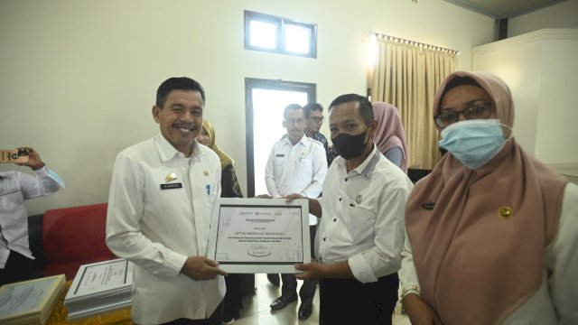 Sekretaris Daerah Kabupaten Luwu Utara, Armiadi turut menyerahkan sertfikat penghargaan kepada salah satu sekolah yang telah mensukseskan program Healthier Smiles. (Istimewa)