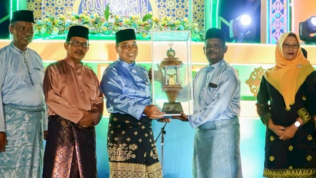Bupati Lingga Muhammad Nizar, menyerahkan Piala juara umum STQH X tingkat Kabupaten Lingga kepada Camat Singkep Barat, Febrizal Taufik. (Foto: Diskominfo Lingga)