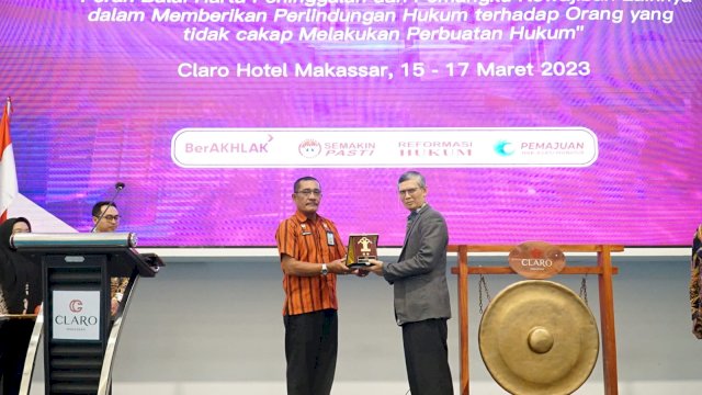 Kanwil Kemenkumham Sulsel Liberti Sitinjak (kiri) saat memberikan cinderamata kepada Hakim Agung RI Edi Riadi yang telah hadir mengisi Sosialisasi Perlindungan Hukum Hak Keperdataan Anak Dibawah Umur dan Pengampuan, di Hotel Claro Makassar, kemarin. (Dok. Humas Kanwil Kemenkumham Sulsel)