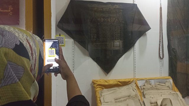 Salah satu pengunjung Museum Balla Lompoa Kabupaten Gowa saat menggunakan barcode dalam mencari informasi terkait koleksi. (Chaerani/Republiknews.co.id)