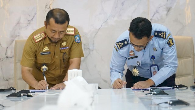 Kadiv Yankumham Kanwil Kemenkumham Sulsel Hernadi dengan Kepala BPKPD Kabupaten Bulukumba, Andi Sufardiman saat melakukan penandatanganan kerjasama terkait pembuatan naskah akademik dalam penyusunan Ranperda tentang Pajak Daerah dan Retribusi Daerah, di Ruang Rapat Pimpinan Kanwil Kemenkumham Sulsel. (Dok. Humas Kanwil Kemenkumham Sulsel)