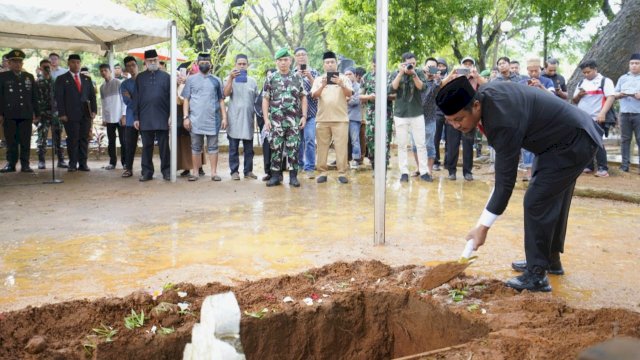 Gubernur Sulsel Andi Sudirman Sulaiman, saat memasukan tanah pertama saat prosesi pemakaman Almarhum Anggota DPR RI Muhammad Rapsel Ali, Senin (10/04/2023). (Istimewa)