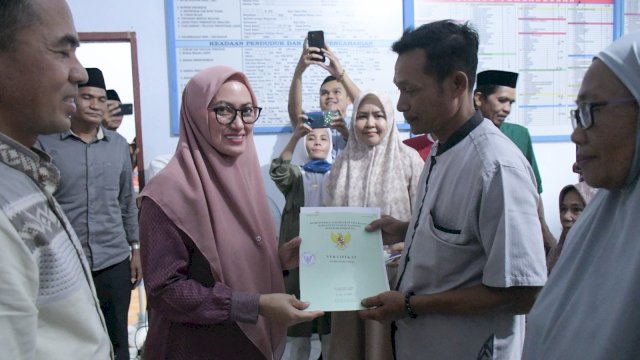 Bupati Luwu Utara Indah Putri Indriani menyerahkan sertifikat kepada slah satu masyarakat Desa Batang Tongka Kecamatan Bone-bone. Minggu (02/04/2023)