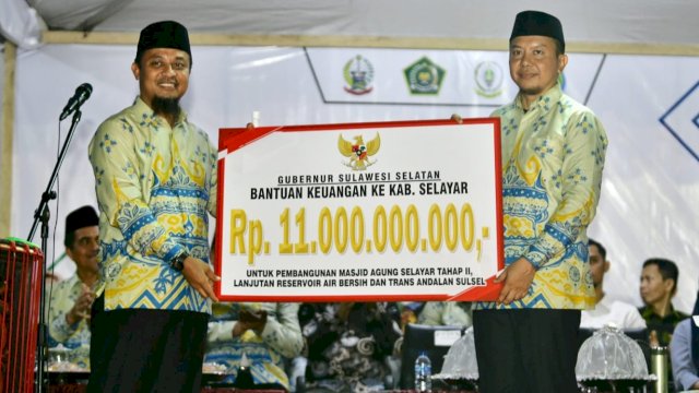 Gubernur Sulsel Andi Sudirman Sulaiman, menyerahkan saat Bantuan Keuangan secara simbolis kepada Bupati Selayar Basli Ali, Selasa (02/05/2023). (Istimewa)