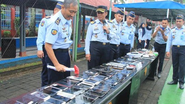 Kepala Divisi Pemasyarakatan Kanwil Kemenkumham Sulsel Suprapto (tengah) saat melakukan pemusnahan barang sitaan, di Lapangan Tennis Lapas Kelas I Makassar, kemarin. (Dok. Humas Kanwil Kemenkumham Sulsel)